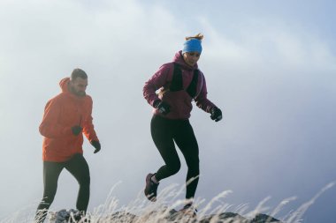 Dağ yolunda koşan bir çiftin izini sürüyorum. Bir çift sabahın erken saatlerinde kros koşusu yapıyor..