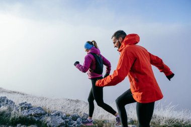 Dağ yolunda koşan bir çiftin izini sürüyorum. Bir çift sabahın erken saatlerinde kros koşusu yapıyor..