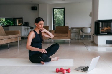 Genç Güzel Kadın Egzersiz, Esneme ve Egzersiz Yogası Parlak Sunny House 'da Video Çağrı Konferansı aracılığıyla Antrenörle. Sağlıklı Yaşam Tarzı, Refah ve Farkındalık Konsepti