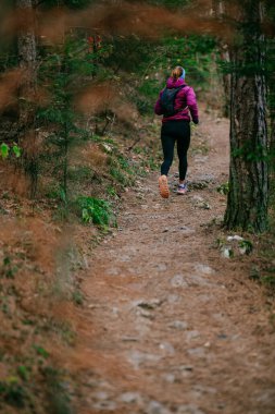 Yoğun Çam Ormanı 'nda Odaklanarak Koşan Kararlı Kadın Atletizm Gücü ve Doğayı Kucaklayan.