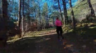 Dağlardaki bir sonbahar ormanında koşan dişi bir koşucunun gizli bir fotoğrafı. Sabah sporları aktif yaşam tarzı, uygunluk, dayanıklılık ve doğa odaklı eğitim maratonunu gözler önüne seriyor