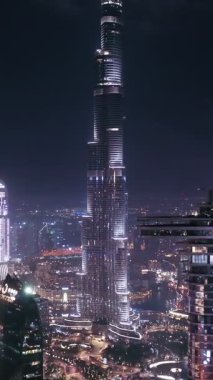 İkonik gökdelenlerin gece görüşü ve Dubai, BAE 'deki büyük bir kavşakta yoğun trafik. Modern bir şehrin çarpıcı silueti iş, finans ve kentsel gelişimi sembolize ediyor..