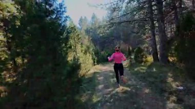 Dağlardaki bir sonbahar ormanında koşan dişi bir koşucunun gizli bir fotoğrafı. Sabah sporları aktif yaşam tarzı, uygunluk, dayanıklılık ve doğa odaklı eğitim maratonunu gözler önüne seriyor