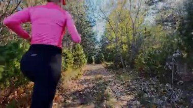 Dağlardaki bir sonbahar ormanında koşan dişi bir koşucunun gizli bir fotoğrafı. Sabah sporları aktif yaşam tarzı, uygunluk, dayanıklılık ve doğa odaklı eğitim maratonunu gözler önüne seriyor