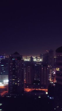 İkonik gökdelenlerin gece görüşü ve Dubai, BAE 'deki büyük bir kavşakta yoğun trafik. Modern bir şehrin çarpıcı silueti iş, finans ve kentsel gelişimi sembolize ediyor..