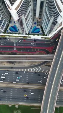 Yoğun trafiğin yüksek açılı üst görüntüsü yoğun saatlerde Dubai 'deki çok katmanlı otoyol ve üstgeçitlerde akıyor. Modern şehir altyapısı, ulaşım ağı ve günlük şehir seyahati kavramı.