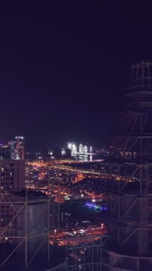 İkonik gökdelenlerin gece görüşü ve Dubai, BAE 'deki büyük bir kavşakta yoğun trafik. Modern bir şehrin çarpıcı silueti iş, finans ve kentsel gelişimi sembolize ediyor..