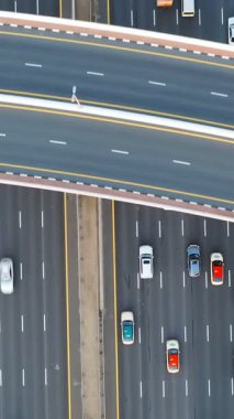 Yoğun trafiğin yüksek açılı üst görüntüsü yoğun saatlerde Dubai 'deki çok katmanlı otoyol ve üstgeçitlerde akıyor. Modern şehir altyapısı, ulaşım ağı ve günlük şehir seyahati kavramı.