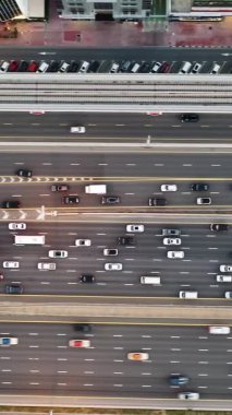 Yoğun trafiğin yüksek açılı üst görüntüsü yoğun saatlerde Dubai 'deki çok katmanlı otoyol ve üstgeçitlerde akıyor. Modern şehir altyapısı, ulaşım ağı ve günlük şehir seyahati kavramı.