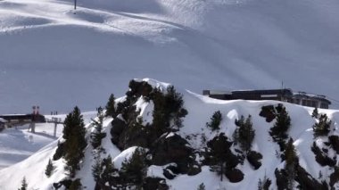 Karla kaplı dağların, güneşli gökyüzünün ve kayak, snowboard, yürüyüş ve açık hava maceraları için mükemmel manzaralı yamaçların nefes kesici hava manzarası.