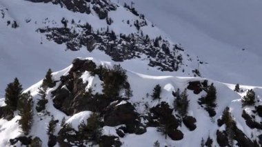 Karla kaplı dağların, güneşli gökyüzünün ve kayak, snowboard, yürüyüş ve açık hava maceraları için mükemmel manzaralı yamaçların nefes kesici hava manzarası.