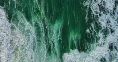 Sersemletici yukarıdan aşağıya güçlü derin mavi okyanus dalgalarının muson mevsiminde beyaz köpükle çarpışını gösteren tropikal deniz manzarası seyahat, doğa ve manzaralı yaz arkaplanları için mükemmeldir.