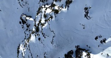 Karla kaplı dağların, güneşli gökyüzünün ve kayak, snowboard, yürüyüş ve açık hava maceraları için mükemmel manzaralı yamaçların nefes kesici hava manzarası.