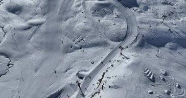 Karla kaplı dağların, güneşli gökyüzünün ve kayak, snowboard, yürüyüş ve açık hava maceraları için mükemmel manzaralı yamaçların nefes kesici hava manzarası.
