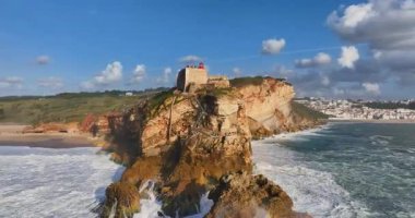 Güneş batarken kayalık bir kıyıya çarpan derin mavi okyanus dalgalarının dramatik hava manzarası bu sakin tropikal deniz manzarasını güzelleştirir. Seyahat, tatil ve doğa temaları için mükemmeldir..