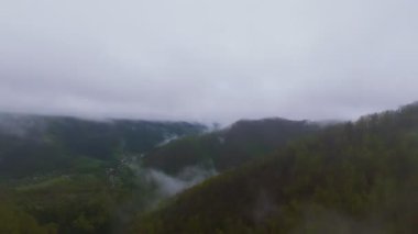 Bereketli ormanlarla kaplı sisli yeşil dağların havadan görünüşü bulutlu bir gökyüzünün altında sürüklenen sis seyahat, macera ve doğa turizmi için mükemmel doğal bir manzara yaratıyor..