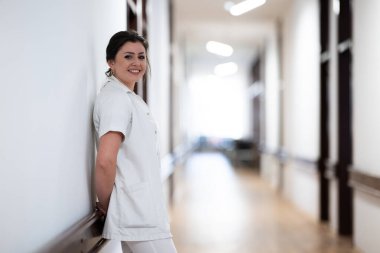 Yorgun bir hemşire hastane koridorunda dinlenmek için uzun ve zahmetli bir vardiyaya kafa yorar.