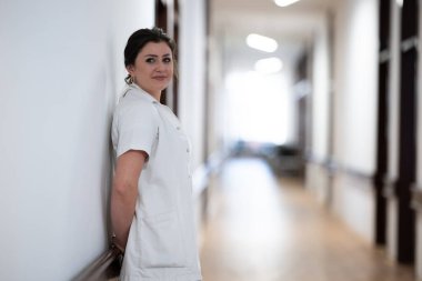 Yorgun bir hemşire hastane koridorunda dinlenmek için uzun ve zahmetli bir vardiyaya kafa yorar.