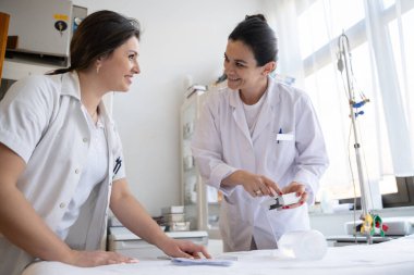 Bir hastane laboratuvarında iki hemşire hastalar ve hastane kullanımı için ilaçları dikkatlice inceliyor ve hazırlıyorlar.