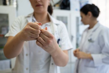 Bir hastane laboratuvarında iki hemşire hastalar ve hastane kullanımı için ilaçları dikkatlice inceliyor ve hazırlıyorlar.
