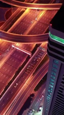 İkonik gökdelenlerin gece görüşü ve Dubai, BAE 'deki büyük bir kavşakta yoğun trafik. Modern bir şehrin çarpıcı silueti iş, finans ve kentsel gelişimi sembolize ediyor..