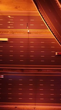 Parlayan gece trafiğinin, akıllı Dubai şehrindeki fütüristik gökdelenlerle çevrili otoyol kavşaklarından dokumasının en üst görüntüsü. Canlı şehir ışıkları, modern ufuk çizgisi ve şehir mimarisi.
