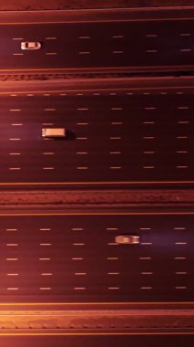 Parlayan gece trafiğinin, akıllı Dubai şehrindeki fütüristik gökdelenlerle çevrili otoyol kavşaklarından dokumasının en üst görüntüsü. Canlı şehir ışıkları, modern ufuk çizgisi ve şehir mimarisi.