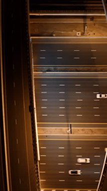 Parlayan gece trafiğinin, akıllı Dubai şehrindeki fütüristik gökdelenlerle çevrili otoyol kavşaklarından dokumasının en üst görüntüsü. Canlı şehir ışıkları, modern ufuk çizgisi ve şehir mimarisi.
