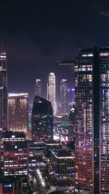 İkonik gökdelenlerin gece görüşü ve Dubai, BAE 'deki büyük bir kavşakta yoğun trafik. Modern bir şehrin çarpıcı silueti iş, finans ve kentsel gelişimi sembolize ediyor..