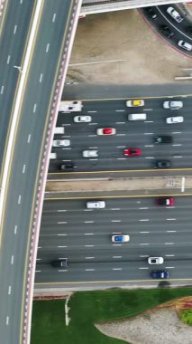 Yoğun trafiğin yüksek açılı üst görüntüsü yoğun saatlerde Dubai 'deki çok katmanlı otoyol ve üstgeçitlerde akıyor. Modern şehir altyapısı, ulaşım ağı ve günlük şehir seyahati kavramı.