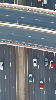 Yoğun trafiğin yüksek açılı üst görüntüsü yoğun saatlerde Dubai 'deki çok katmanlı otoyol ve üstgeçitlerde akıyor. Modern şehir altyapısı, ulaşım ağı ve günlük şehir seyahati kavramı.