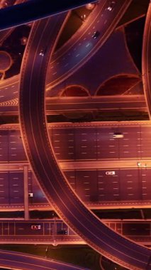 Parlayan gece trafiğinin, akıllı Dubai şehrindeki fütüristik gökdelenlerle çevrili otoyol kavşaklarından dokumasının en üst görüntüsü. Canlı şehir ışıkları, modern ufuk çizgisi ve şehir mimarisi.
