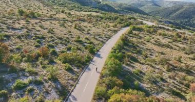 Zorlu bir dağ tırmanışında bisiklete binen enerjik profesyonel kadın yol bisikletçisi, yoğun eğitim ve sağlıklı açık hava yaşam tarzı spor, aktif yaşam ve atletik yaşam için mükemmel.