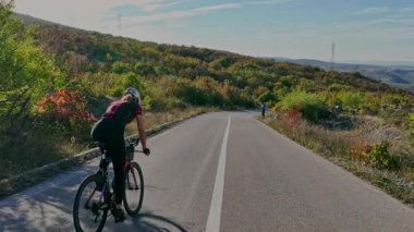 Zorlu bir dağ tırmanışında bisiklete binen enerjik profesyonel kadın yol bisikletçisi, yoğun eğitim ve sağlıklı açık hava yaşam tarzı spor, aktif yaşam ve atletik yaşam için mükemmel.
