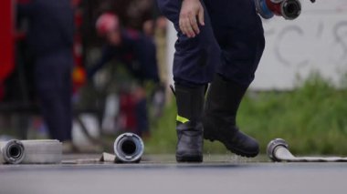İtfaiyecilerden oluşan özel bir ekip bir itfaiye aracından hortumları alıyor ve tehlikeli bir tehlikeyle mücadele etmedeki cesaret ve profesyonel uzmanlıklarını sergileyerek, yanan bir yangını söndürmek için tehlikeli bir göreve çıkıyorlar.