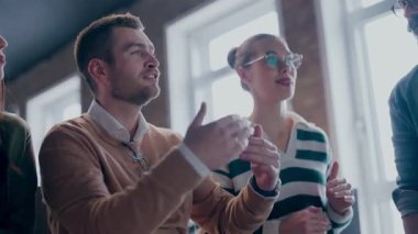 Moden ofis alanı, iş dünyasından profesyonellerden oluşan bir ekip canlı tartışmalara girişiyor ve stratejik fikirleri paylaşıyor, modern kurumsal açık alanların merkezinde işbirliği ve yenilik sergiliyor.