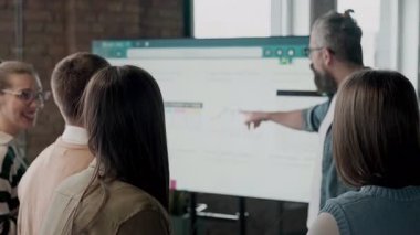 Moden ofis alanı, iş dünyasından profesyonellerden oluşan bir ekip canlı tartışmalara girişiyor ve stratejik fikirleri paylaşıyor, modern kurumsal açık alanların merkezinde işbirliği ve yenilik sergiliyor.