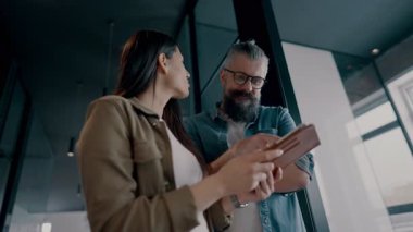 Yaratıcı milenyumlar, sıradan iş adamları, küçük işletme sahipleri, sosyal medya stratejisi ve marka geliştirme üzerinde çalışan modern, açık bir ofis ortamında dijital tabletle