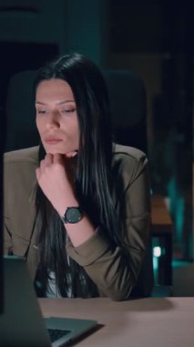 Ofiste geç saatlere kadar çalışan bayan iş kadını yorgun ve bitkin hissederken dizüstü bilgisayar kullanıyor. Okuma, kopyalama, düzenleme, ve sıkışık bir son tarihte yorgunluk ve beyin sisi ile mücadele