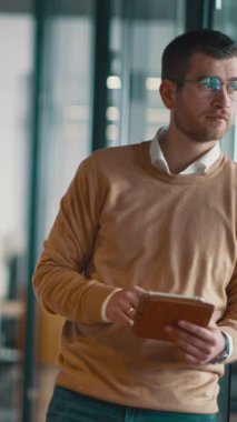 Üst düzey iş adamı, bilişim uzmanı, tüccar ve kripto yatırımcısı modern bir çalışma alanında dijital tablet kullanıyor. Açık ofis ortamında çalışan teknoloji meraklısı bir profesyonel..