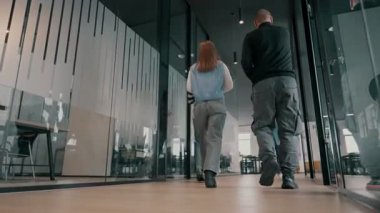 Modern bir açık mekan ofisinin iş ekibi birlikte yürüyor. Çeşitli iş adamları tartışırken gülümsüyor. Başarılı karma ırk meslektaşları yeni bir projede işbirliği yapıyorlar