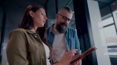 Yaratıcı milenyumlar, sıradan iş adamları, küçük işletme sahipleri, sosyal medya stratejisi ve marka geliştirme üzerinde çalışan modern, açık bir ofis ortamında dijital tabletle