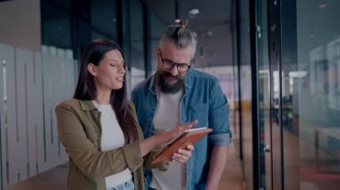 Yaratıcı milenyumlar, sıradan iş adamları, küçük işletme sahipleri, sosyal medya stratejisi ve marka geliştirme üzerinde çalışan modern, açık bir ofis ortamında dijital tabletle