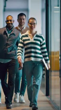 Modern bir açık mekan ofisinin iş ekibi birlikte yürüyor. Çeşitli iş adamları tartışırken gülümsüyor. Başarılı karma ırk meslektaşları yeni bir projede işbirliği yapıyorlar