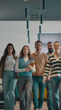 Modern bir açık mekan ofisinin iş ekibi birlikte yürüyor. Çeşitli iş adamları tartışırken gülümsüyor. Başarılı karma ırk meslektaşları yeni bir projede işbirliği yapıyorlar