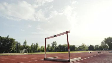 İş adamı atletizm pistinde koşarken engelden atlıyor. Yüksek kalite 4 bin yavaş çekim görüntüsü