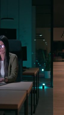 Ofiste geç saatlere kadar çalışan bayan iş kadını yorgun ve bitkin hissederken dizüstü bilgisayar kullanıyor. Okuma, kopyalama, düzenleme, ve sıkışık bir son tarihte yorgunluk ve beyin sisi ile mücadele