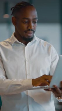 Modern bir ofiste dizüstü bilgisayarı üzerinde çalışan odaklanmış bin yıllık bir iş adamı. Finansal yönetim, bütçe belirleme ve harcamaları izleme stratejileri geliştiriyor.