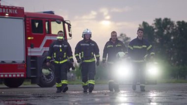 Cesur İtfaiyeciler Ekibi Kameraya Yürüyor. Arka plan Sağlık Ekibi ve İtfaiyeci Kurtarma Ekibi Araba Kazası, Sigorta ve Hayat Kurtarma konseptinde İtfaiyeye Karşı. Yüksek kalite fotoğraf