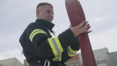 İtfaiyecilerden oluşan özel bir ekip bir itfaiye aracından hortumları alıyor ve tehlikeli bir tehlikeyle mücadele etmedeki cesaret ve profesyonel uzmanlıklarını sergileyerek, yanan bir yangını söndürmek için tehlikeli bir göreve çıkıyorlar.